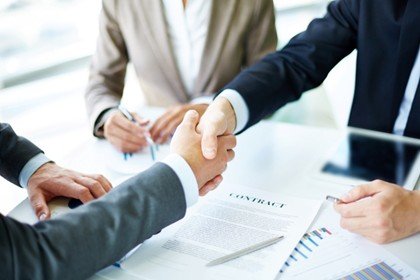 Personas estrechando manos después de firmar contrato en Panamá